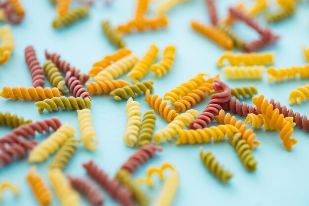 Photo full frame shot of multi colored pasta on blue background