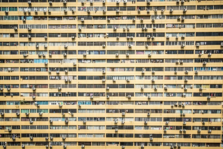 Photo full frame shot of numerous air conditioning units and windows residential building