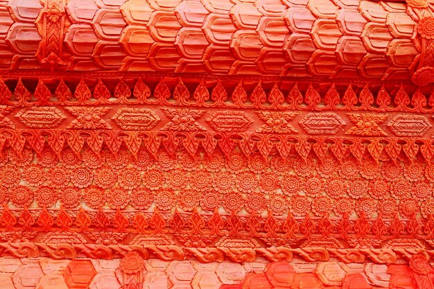 Photo full frame shot of patterned orange carvings on wall