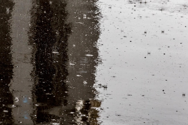 Full frame shot of raindrops on wet asphalt surface