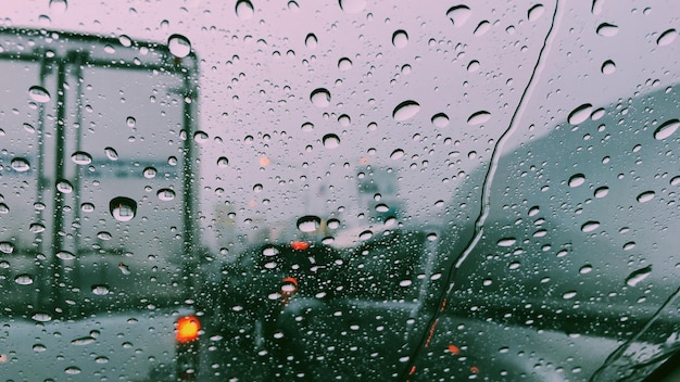 Foto full frame shot van nat glas raam van de auto in het regenseizoen