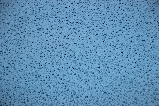 Full frame shot van regendruppels op blauw oppervlak