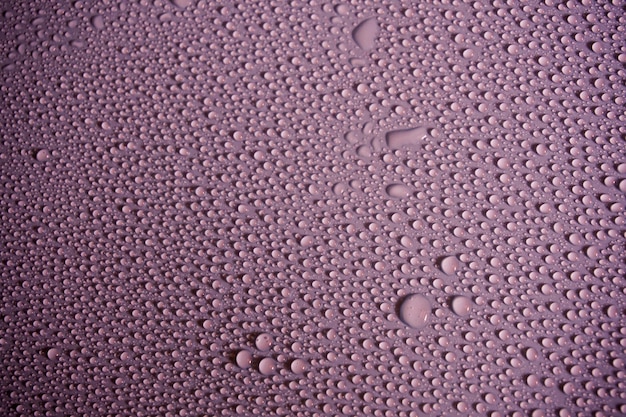 Full frame shot of water drops on pink table