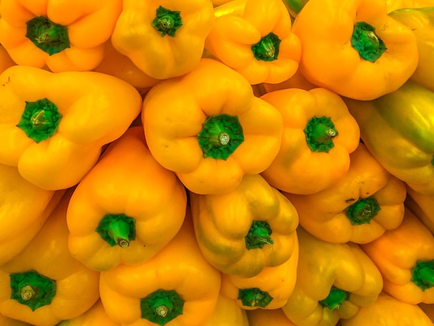 Photo full frame shot of yellow bell peppers for sale at market stall