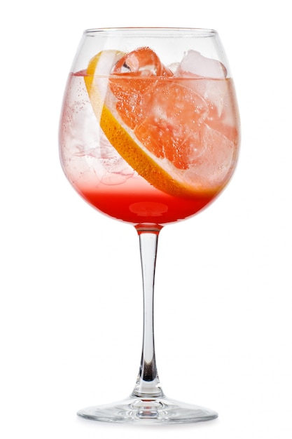 Full glass of fresh cool tonic with grapefruits juice and slices isolated