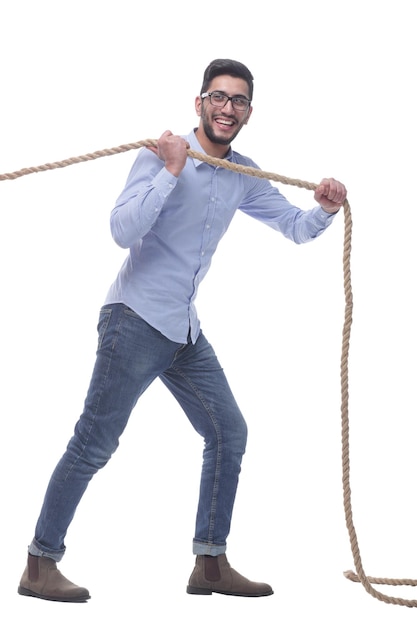 in full growth purposeful young man pulls the rope isolated on a white background