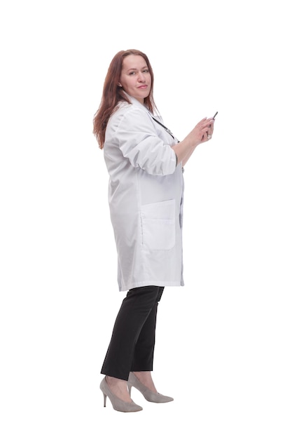 In full growth. qualified female doctor with a smartphone.