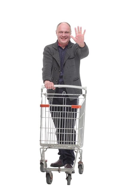 In full growth.smiling casual man with shopping cart .isolated on a white background.