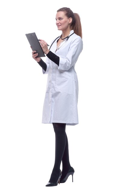 In full growth smiling woman doctor making notes in the clipboard