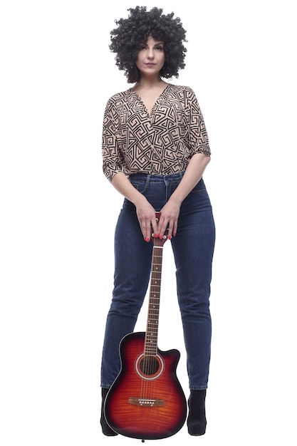 В полном росте стильная молодая женщина с гитарой