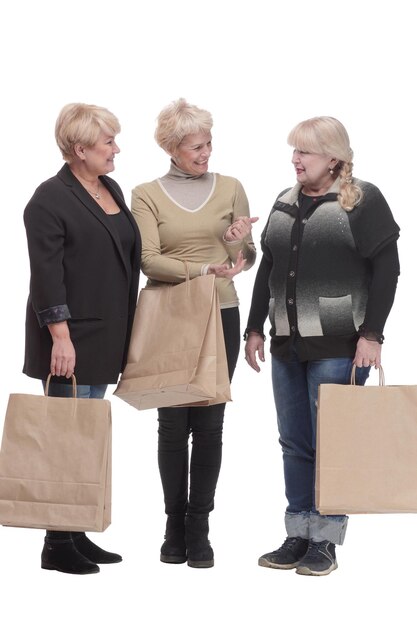 Photo in full growth three happy women with shopping bags