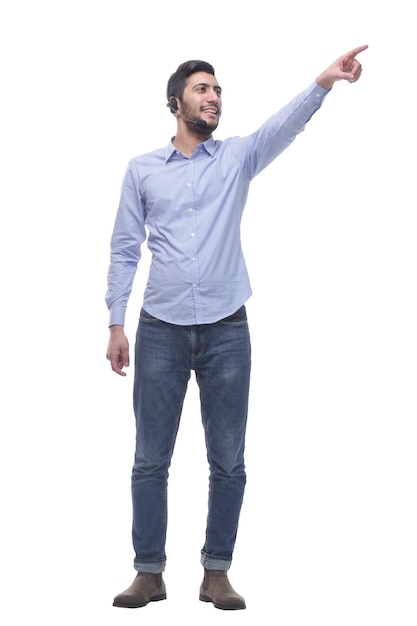 In full growth young man in a headset pointing at a white screen