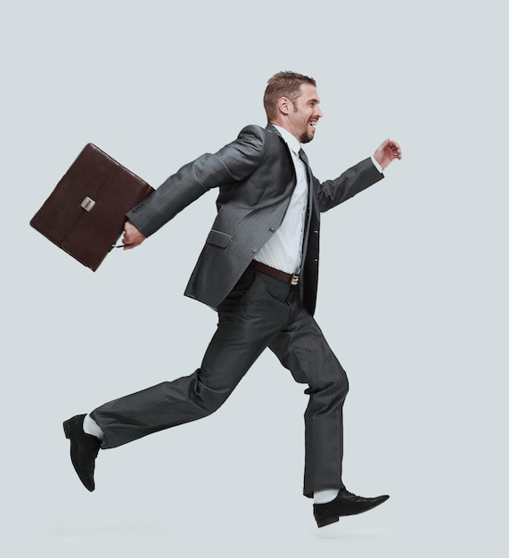 Photo in full growthside viewcheerful businessman with briefcase stepping forward isolated on white background