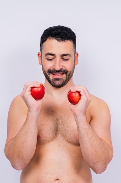 Full isolated studio picture from a young naked man with underwear and tomato