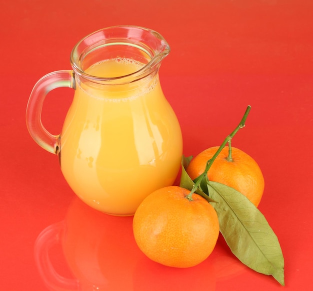 Full jug of orange juice on color background