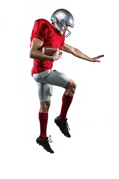 Full length of American football player defending against white background