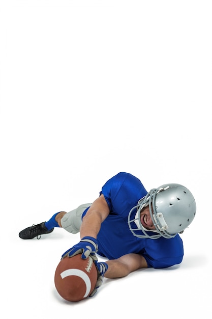 Full length of American football player reaching ball