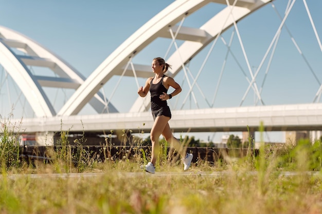 Foto integrale della donna atletica che corre all'aperto