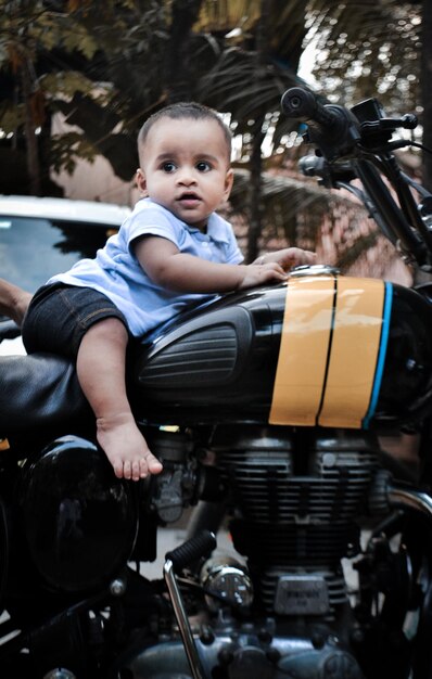 Foto lunghezza completa di un bambino seduto su una motocicletta