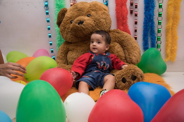 Photo full length of baby boy sitting on toy at home