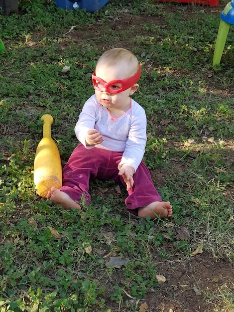 Foto lunghezza completa di una bambina seduta sul campo