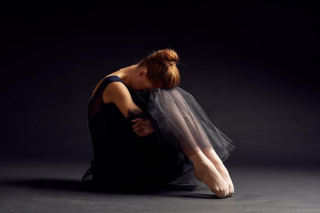 Foto tutta la lunghezza di una ballerina seduta in studio