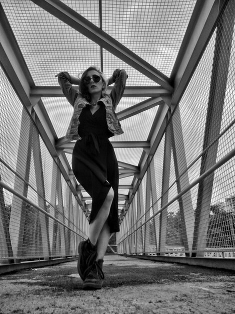 Full length of beautiful woman posing on bridge