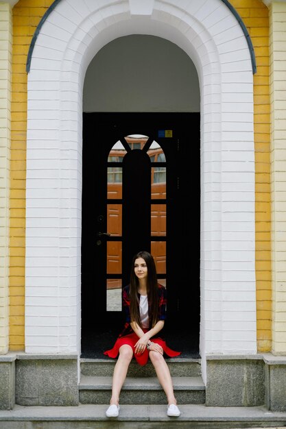 Photo full length of beautiful woman sitting outside building