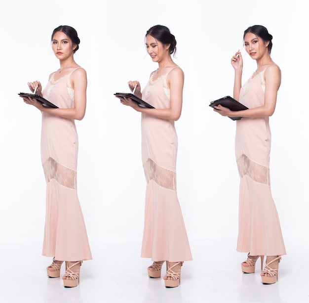 Full length body of Asian beautiful woman wear Pink evening sequin gown working digital tablet