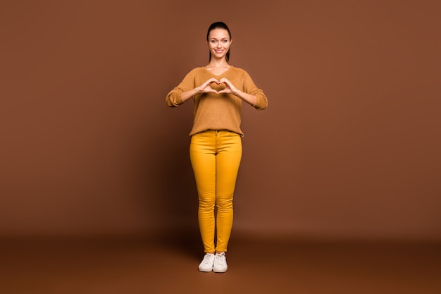 Full length body size   fascinating youngster   showing you heart shape sign demonstrating her love isolated