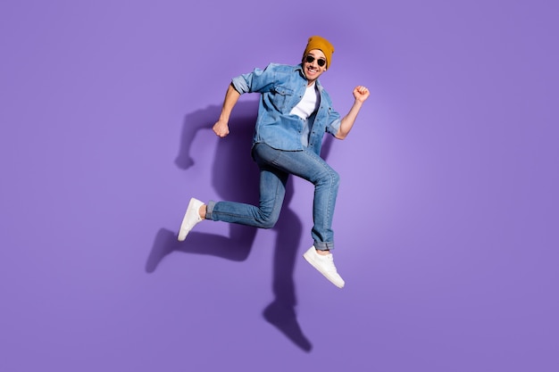 Full length body size photo of ecstatic rejoicing overjoyed guy enjoying sport running trying to reach sales isolated over vivid purple color background