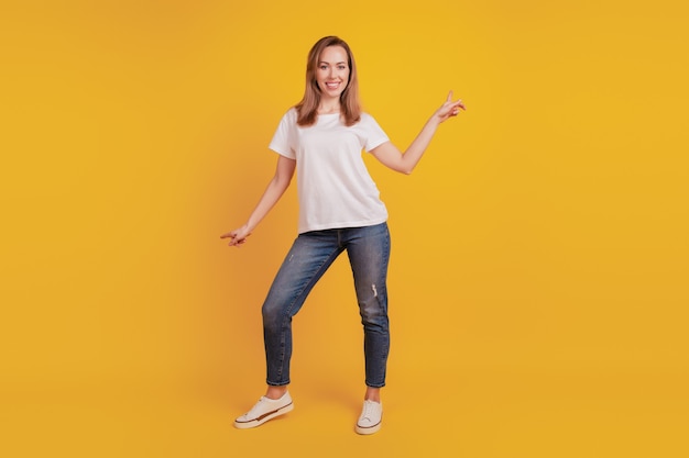 Full length body size of positive glad girl dance enjoy dreamy mood on yellow background