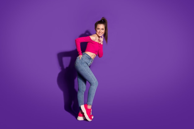 Full length body size profile side view of attractive cheerful curious girl posing touching chin isolated over bright color background