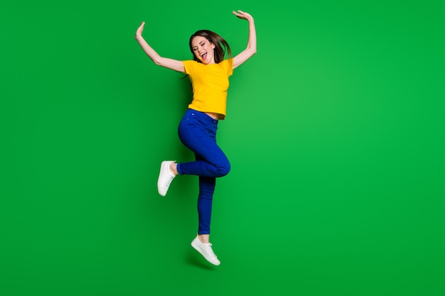 Foto vista a figura intera di una ragazza allegra che salta