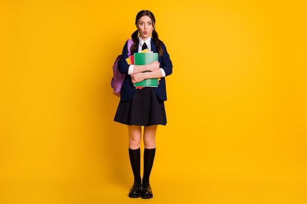 Full length body size view of cute funny schoolgirl holding in hand book