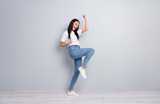 Full length body size view of her she nice attractive lovely cheerful cheery straighthaired girl celebrating success having fun isolated on light grey pastel color background