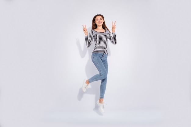 Full length body size view of her she nice attractive lovely pretty cheerful cheery careless carefree straight-haired girl having fun showing double v-sign isolated over white light wall