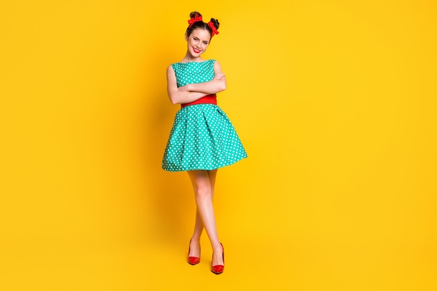 Full length body size view of lovely cheerful girl wearing teal dress folded rams isolated on bright yellow color background