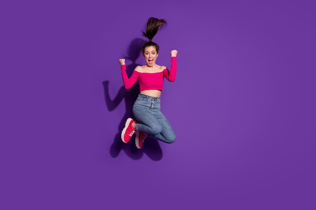 Full length body size view of lovely girlish cheerful overjoyed girl jumping rejoicing isolated on bright violet color background