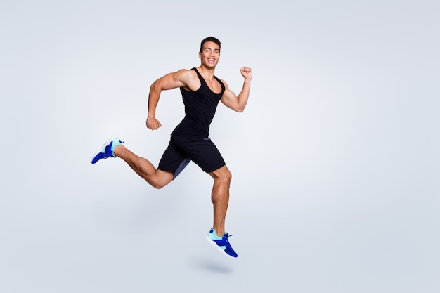 Full length body size view of muscular purposeful guy jumping running jogging sprint distance