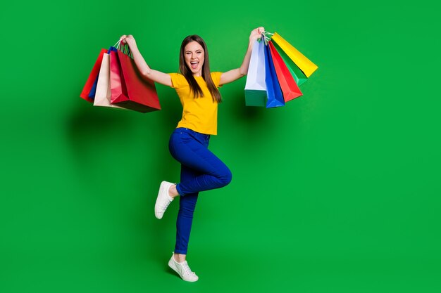 full length body size view portrait of girl jumping carrying packages rejoice