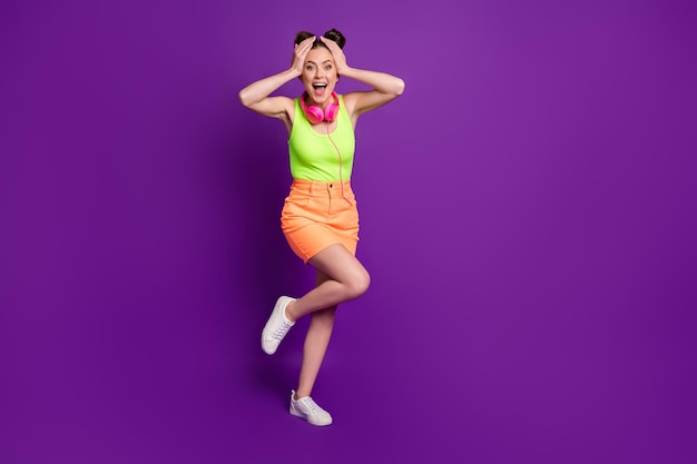 Full length body size view of  pretty amazed cheerful girl listening disco having fun dancing isolated on bright violet color background