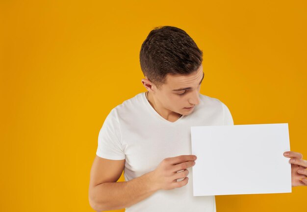 Full length of a boy holding paper against yellow background
