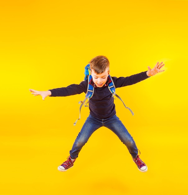 Full length of boy jumping against yellow background