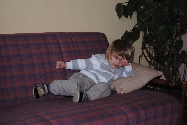 Photo full length of boy lying on sofa at home