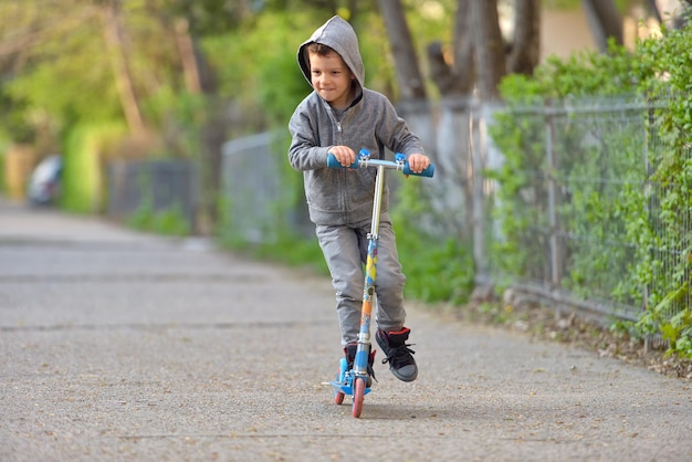 都市でスクーターを押す男の子の全長