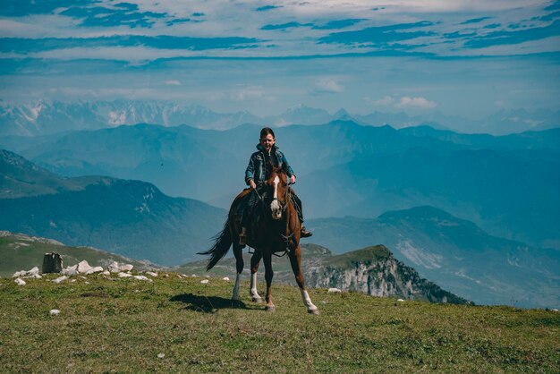 Full length of boy sitting on horse against mountain