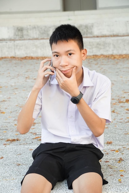 Photo full length of a boy sitting outdoors