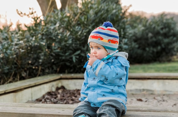 Photo full length of boy sitting in park