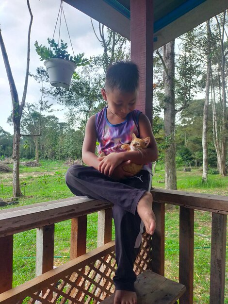 Full length of boy sitting on railing against trees